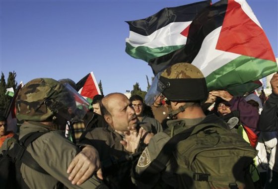 A Palestinian man scuffles with Israeli soldiers during a protest against an Israeli roadblock at the entrance to the West Bank village of Beitin, near Ramallah on Monday.